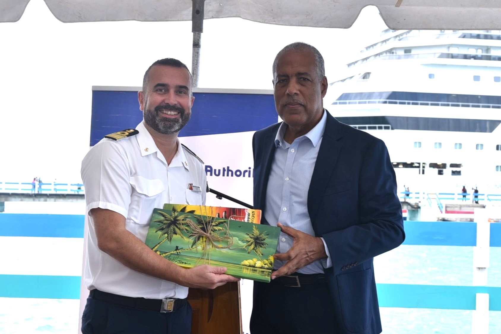 Carnival Sunrise Captain Martino Pellegrini presents artwork to  President & CEO of the Port Authority of Jamaica Gordon Shirley