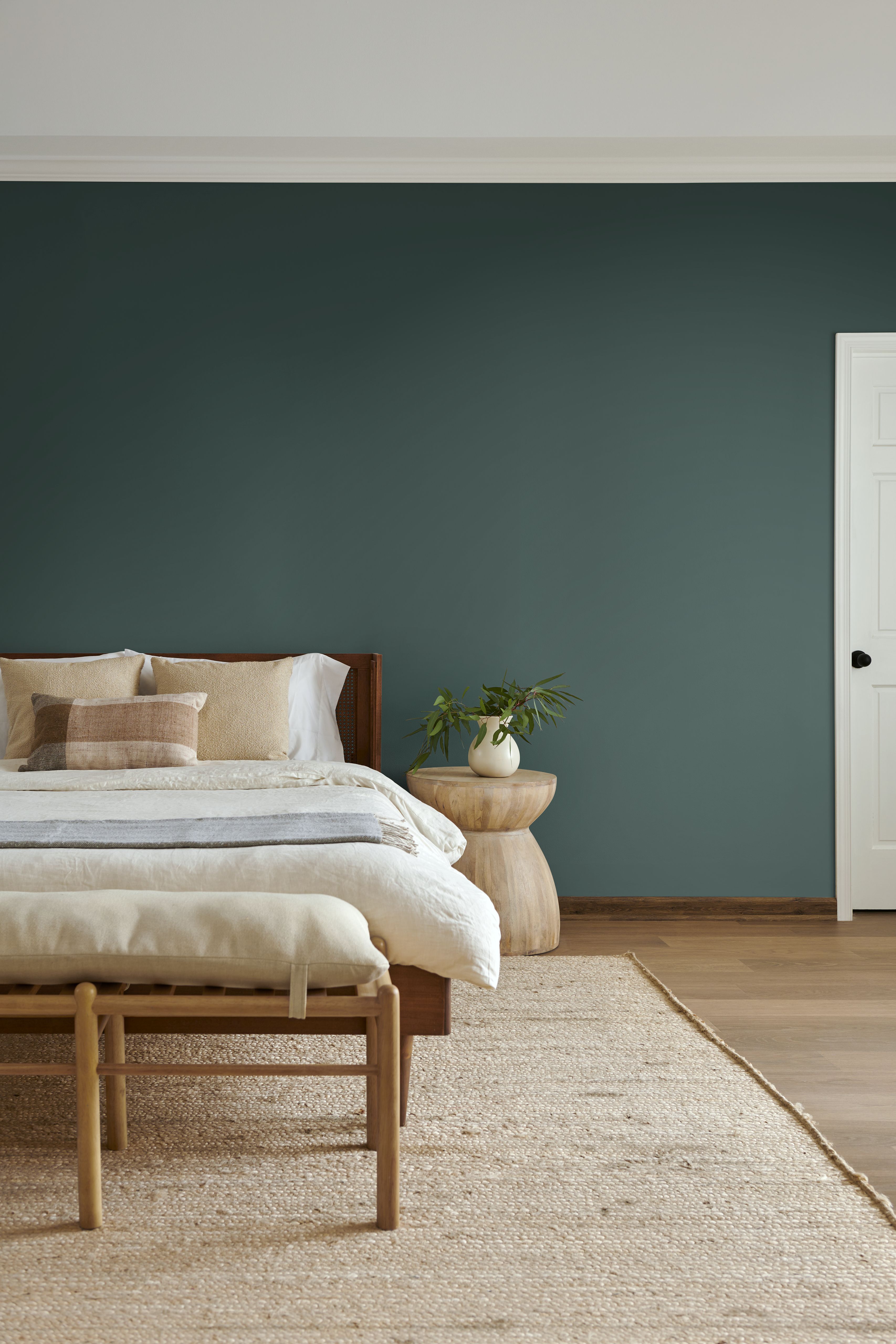 Hidden Gem blue‑green on bedroom wall with natural textures—Behr 2026