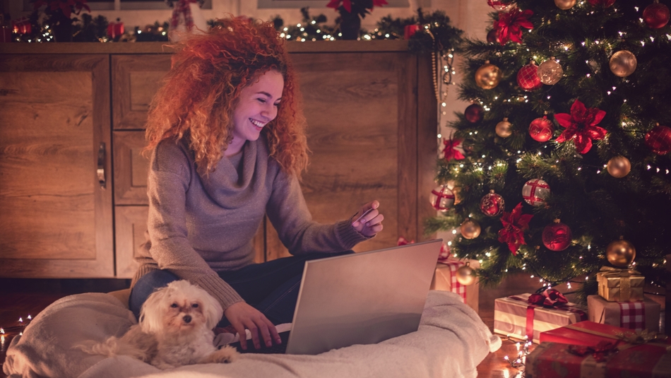 Young Woman with dog and laptop during xmas