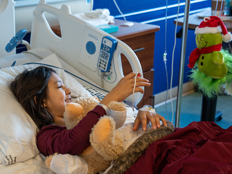 girl-in-bed-gets-grinch-toy