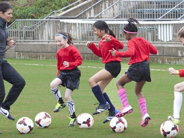Mia Hamm plays soccer with kids