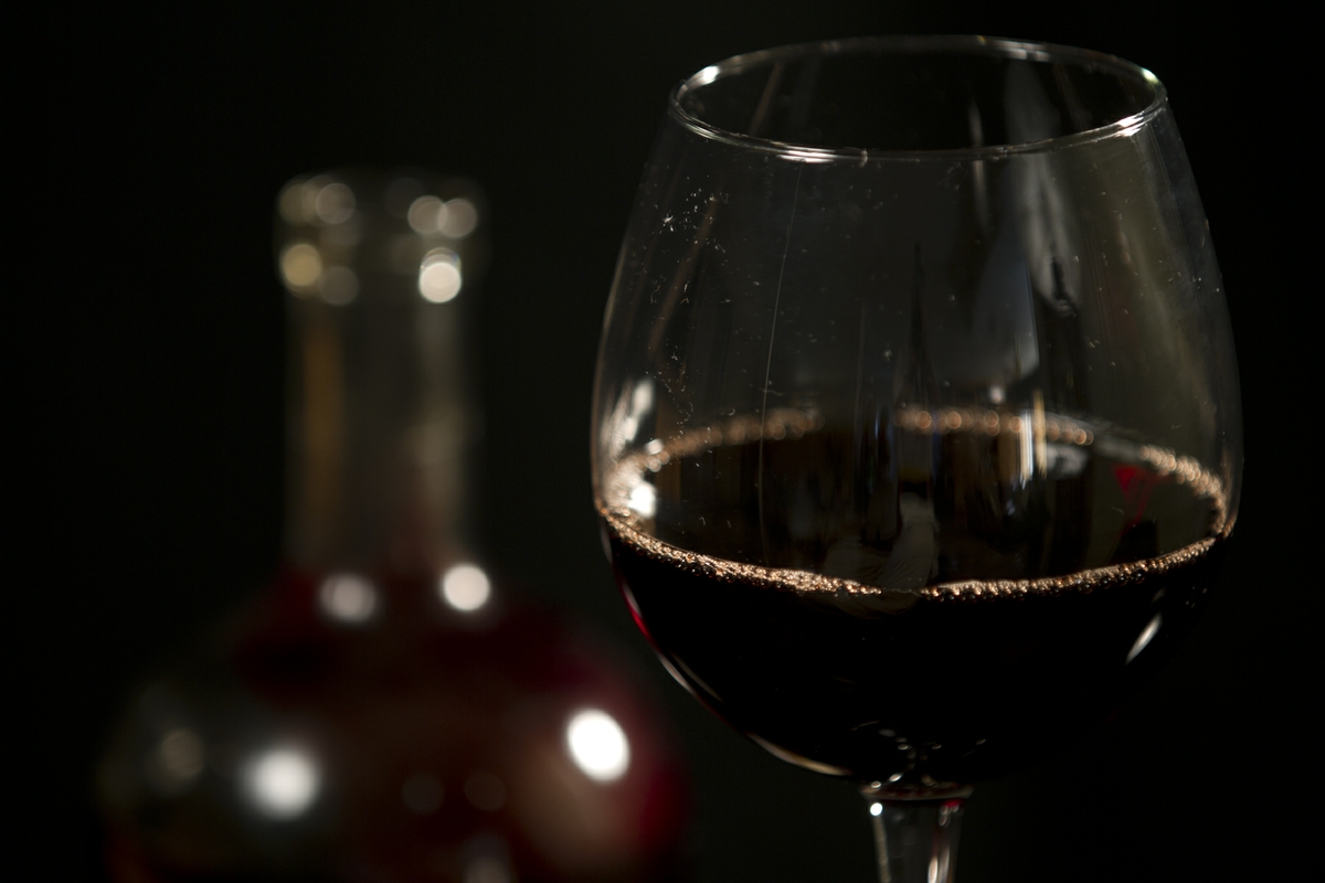 Wine - Red in Glass with bottle close up on glass