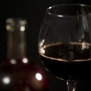 Wine - Red in Glass with bottle close up on glass
