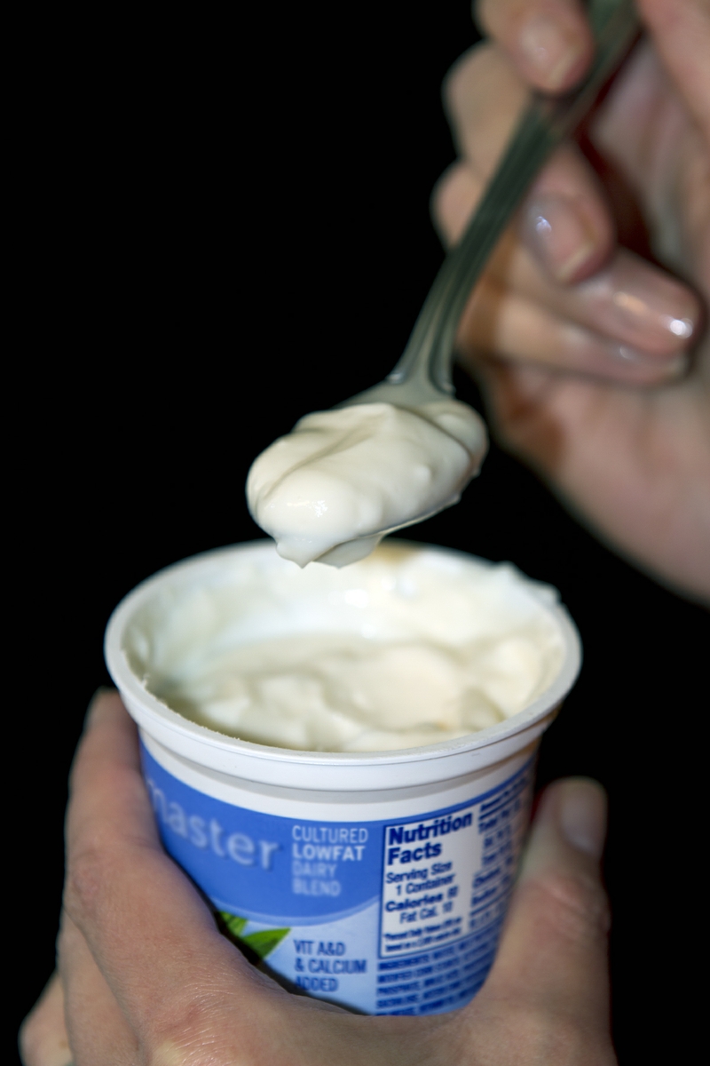Yogurt LowFat plain held with spoon verticle