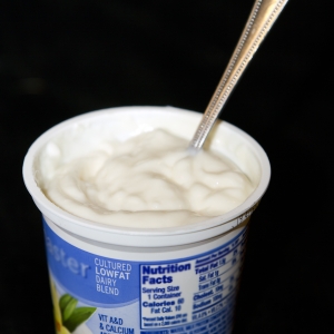 Yogurt LowFat plain in cup with spoon verticle