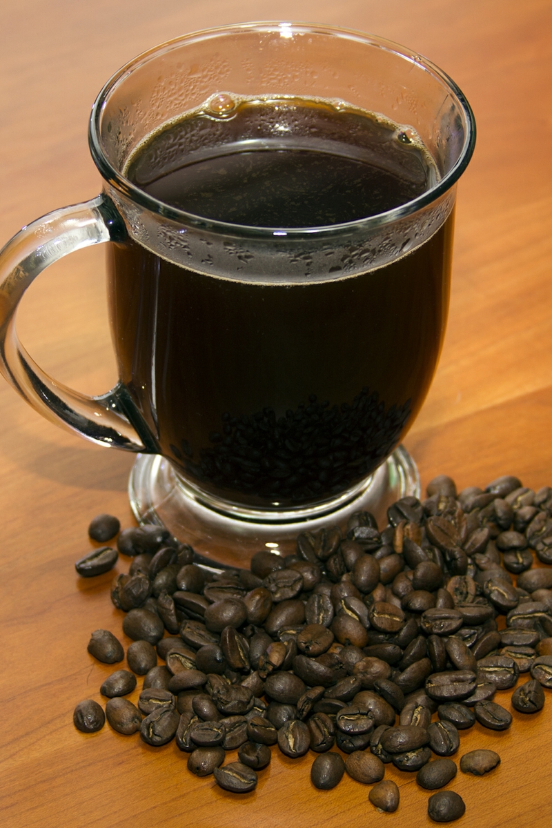 Coffee in Cup with whole beans above Close