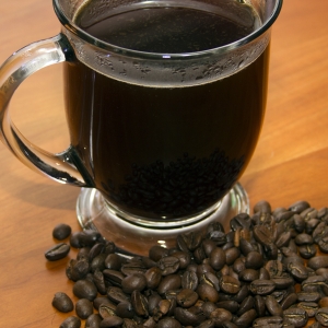 Coffee in Cup with whole beans above Close