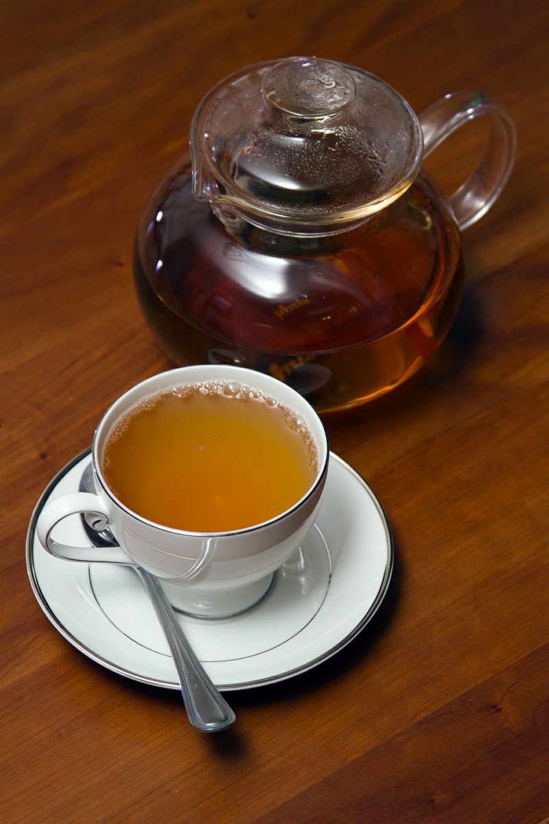 Green Tea in Cup with spoon and Tea Pot Verticle