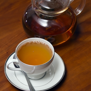 Green Tea in Cup with spoon and Tea Pot Verticle