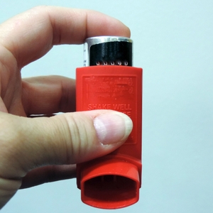 asthma inhaler in hand