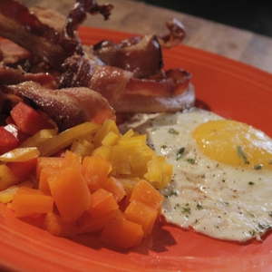 Breakfast plate close up - fried egg, bacon, peppers