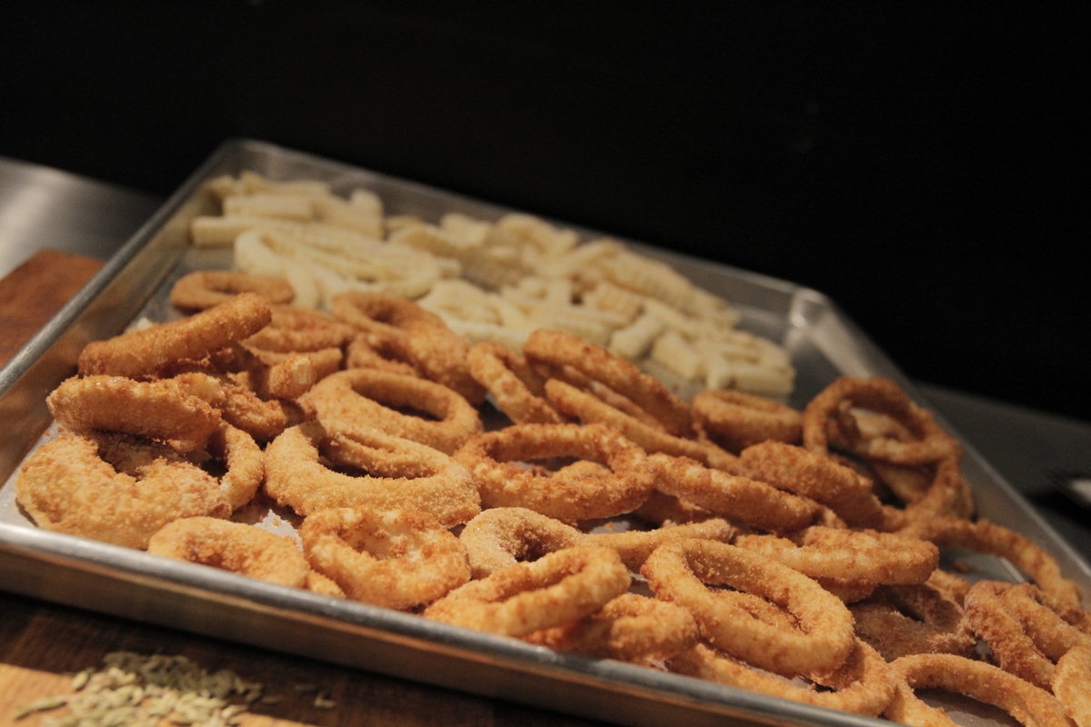 Onion rings and fries in a pan