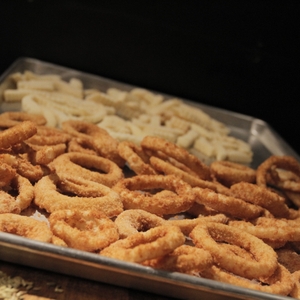 Onion rings and fries in a pan