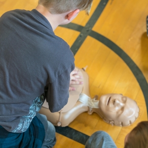 Child practicing CPR during school training 