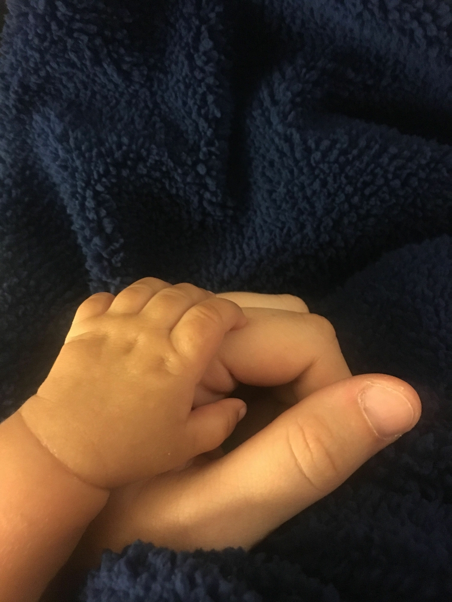 Baby holding mother's hand