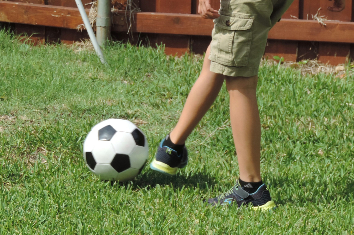 Boy kicks soccer ball