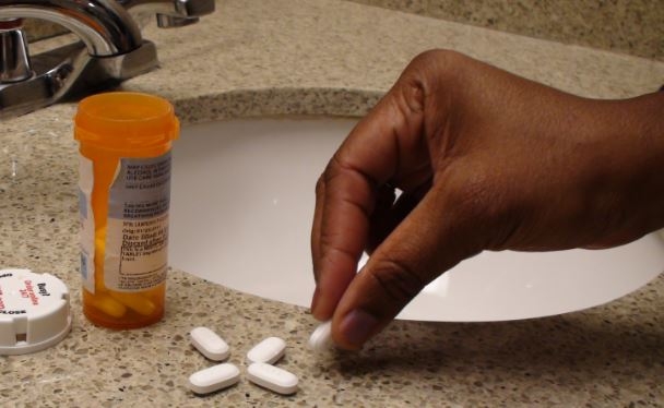 Opioids- women picking up pill