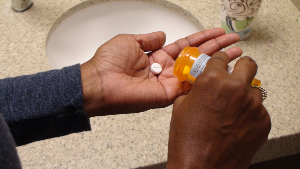 Opioids - women pouring out pill