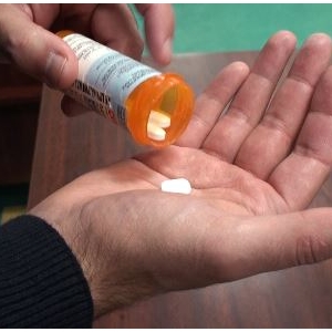 Opioids- man pouring into hand