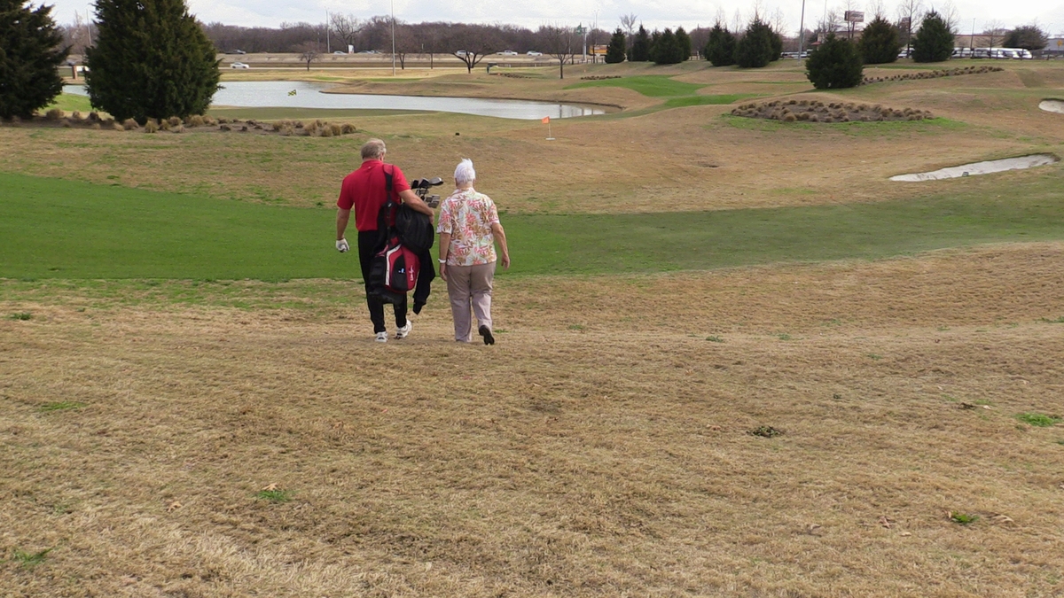 Man and woman walking on golf course