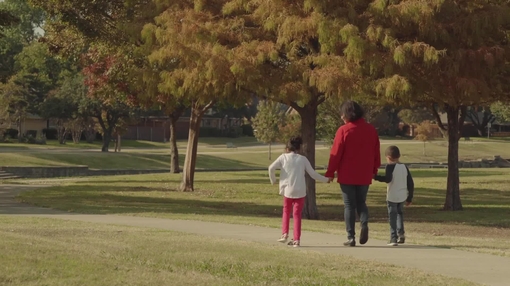 Woman walking with grandchildren at park