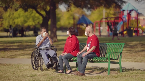 Man with caregivers at a park masks on
