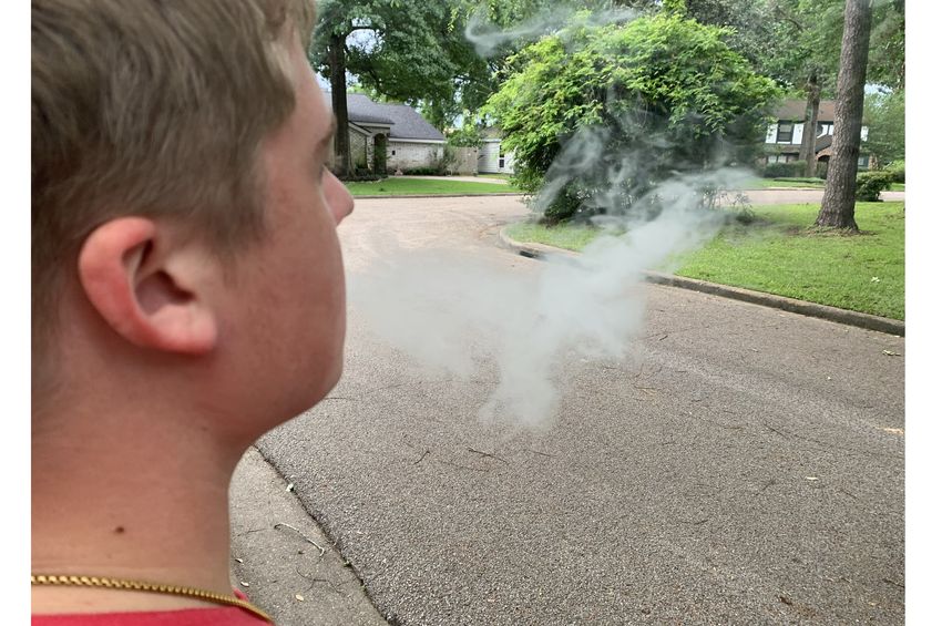 Teen blowing e-cigarette smoke - vaping