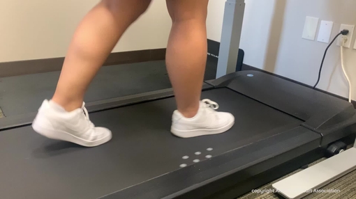 Woman walking on treadmill and checking smart watch