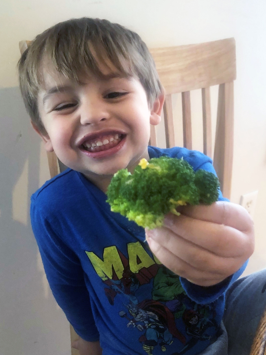 Toddler enjoying broccoli