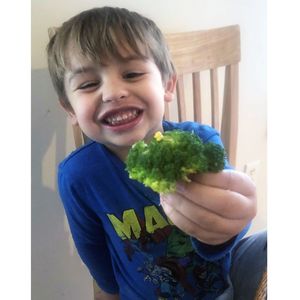 Toddler enjoying broccoli