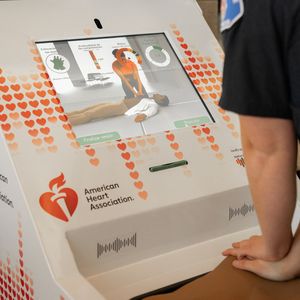 Firefighter demonstrating Hands-Only CPR at kiosk