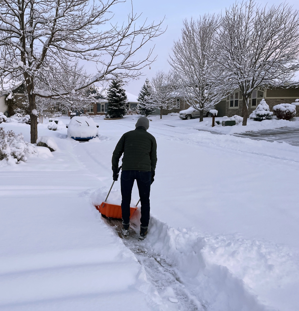 Man clearing snow on sidewalk