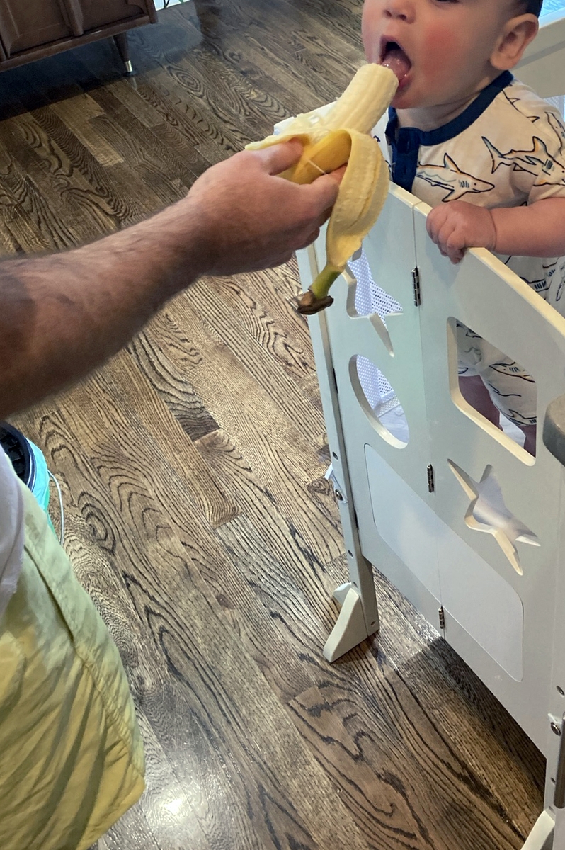 Dad feeding toddler banana