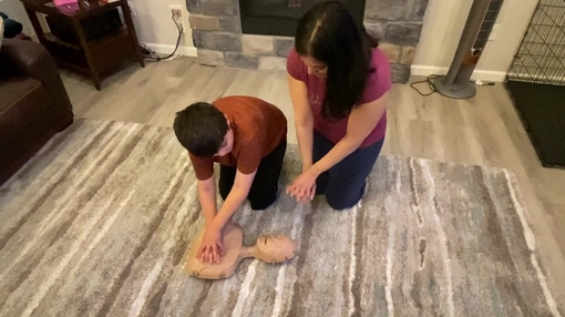 Parents showing children CPR techniques b-roll