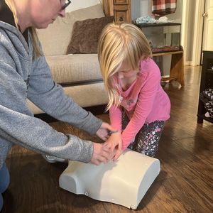 Mom showing daughter CPR hand placement