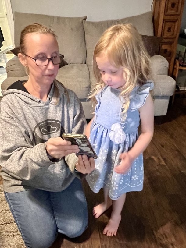 Woman showing child 9-1-1 on phone