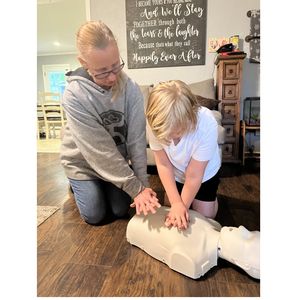 Woman showing child CPR technique