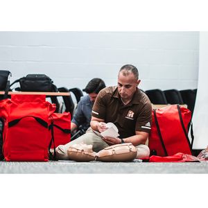 Participant practicing Hands-Only CPR and using an AED