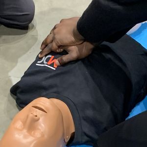 A close up of chest compressions on a CPR mannikin