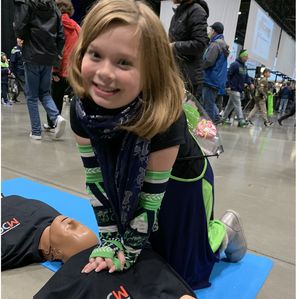 A Seattle Seahawks young fan practices chest compressions