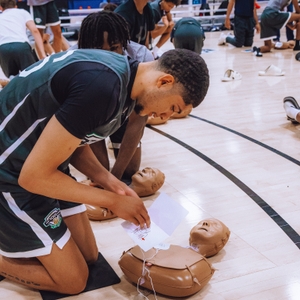Athlete practicing CPR and using an AED