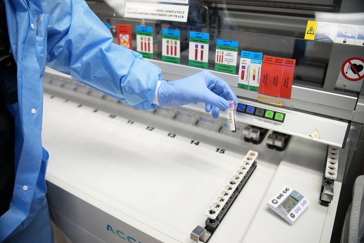 Lab tech adding blood samples to container