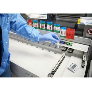 Lab tech adding blood samples to container