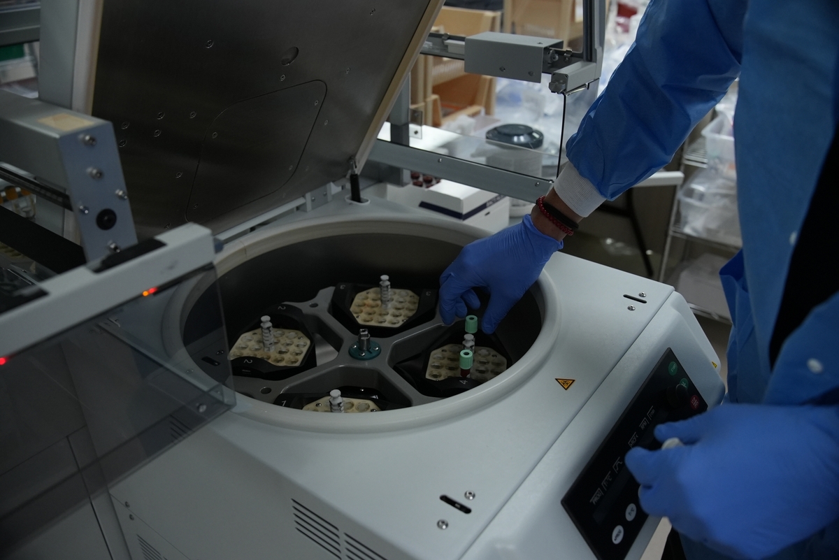 Lab tech adding vials to centrifuge