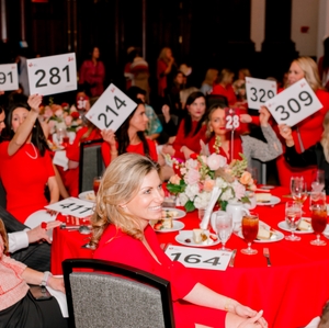   Guests hold bid paddles at local Go Red for Women event