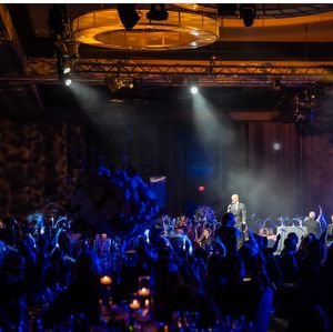 Auctioneer on stage at 2025 Côtes du Coeur