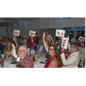 Guests raise their bidder paddles at the 2025 Heart of the Hamptons