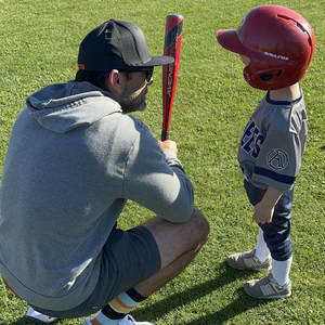 Cole Thompson with his yong son during a baseball game in Aledo