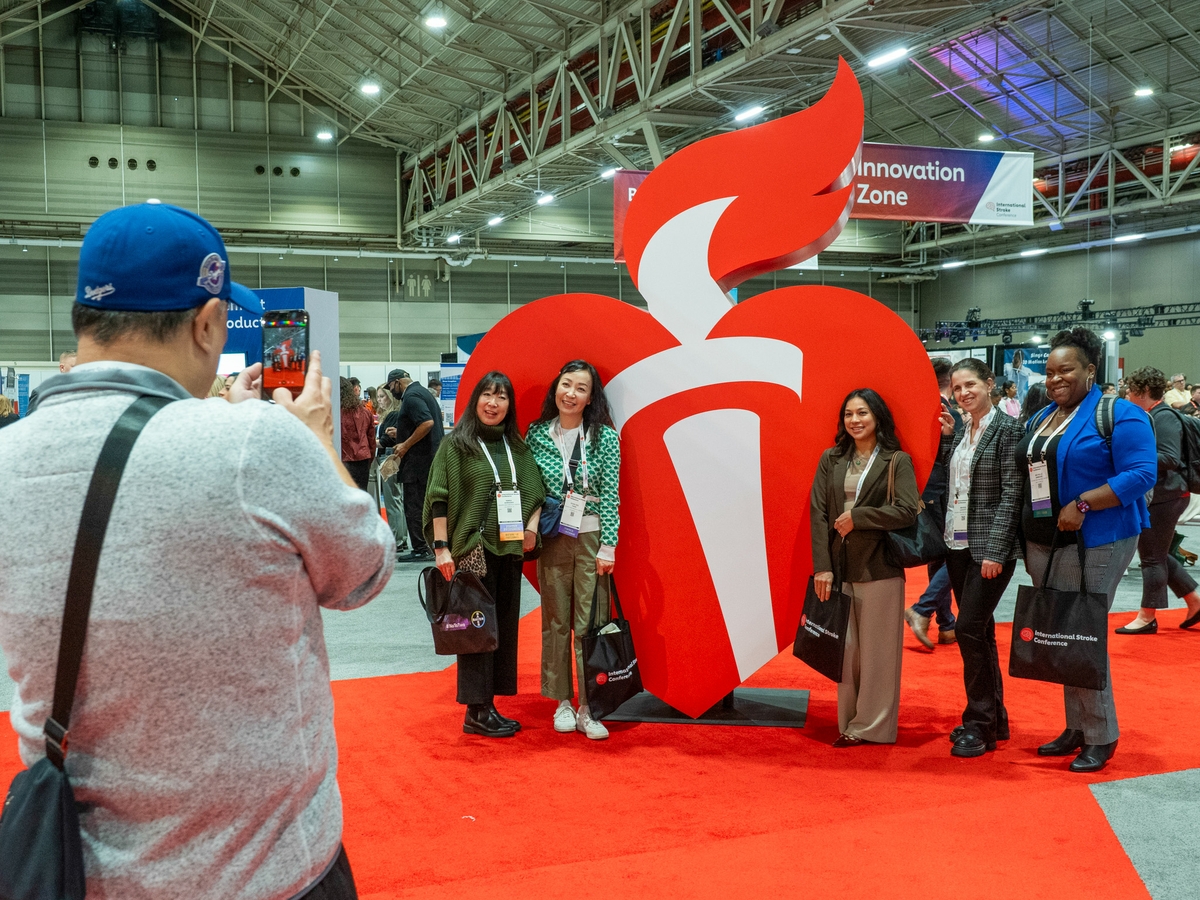 Attendees take photos with heart torch at ISC26