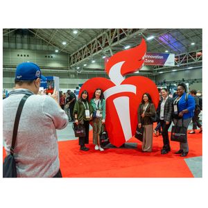 Attendees take photos with heart torch at ISC26